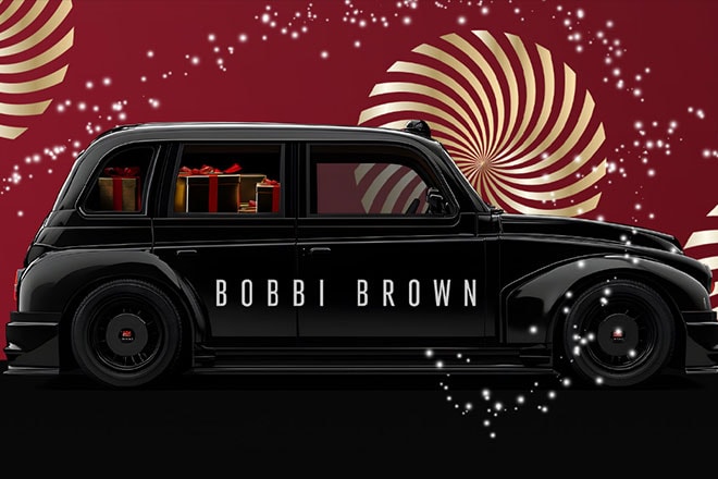 Bobbi Brown black car with gold swirls on a red background
